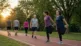 Pessoas se alongando e caminhando em um parque, ilustrando exercício físico e captação de glicose pelo músculo